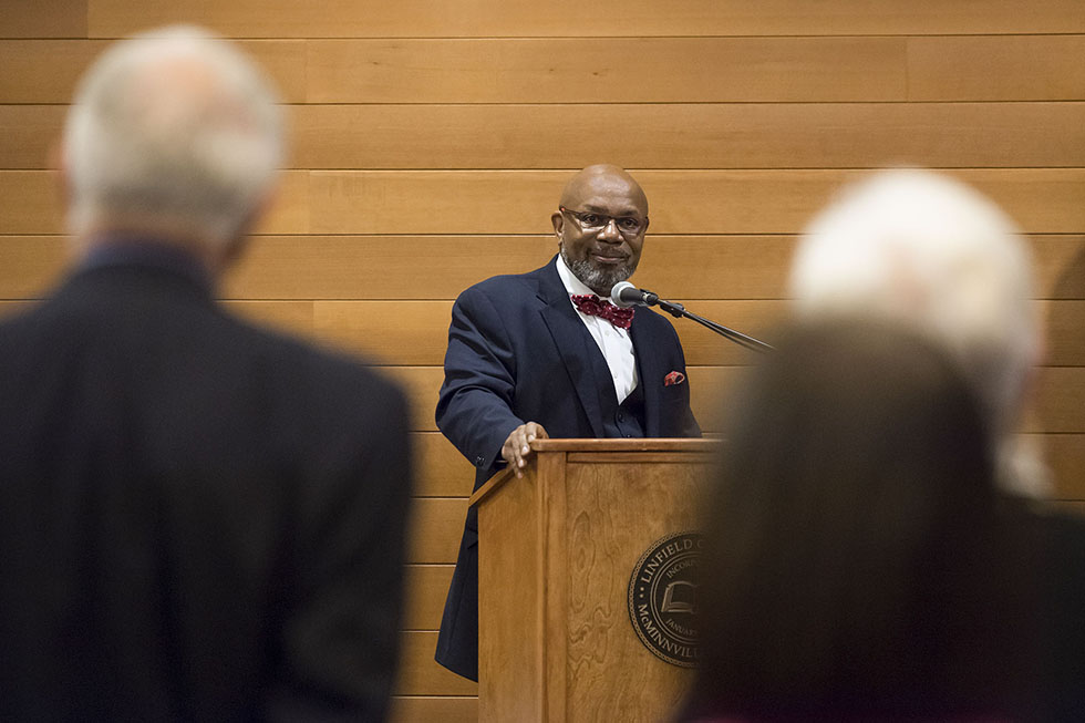 Dr. Miles K. Davis addressing an audience at a Linfield University podium